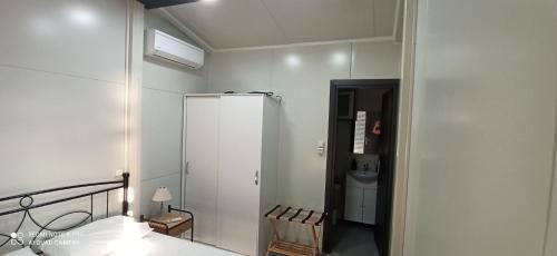 a white room with a bed and a refrigerator at Villa Nikitas Beach in Agios Nikitas