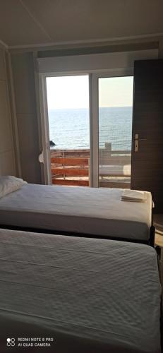 a bedroom with a bed and a view of the ocean at Villa Nikitas Beach in Agios Nikitas