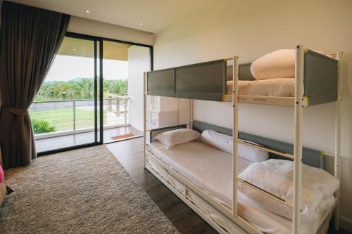 two bunk beds in a room with a balcony at Porsampao Luxury Villa in Ban Khok Khilek