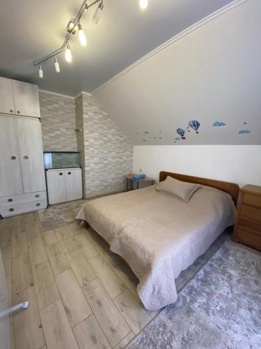 a bedroom with a large bed and a kitchen at Апартаменты in Vinnytsya