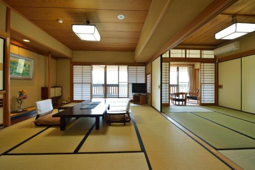 a large living room with a table and chairs at Senkyoro in Hakone