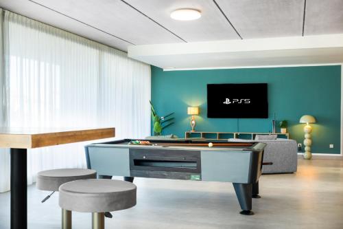 a living room with a pool table and two stools at Luxury Villa Lumina with Arcade & Pool Table, PS5 in Can Picafort