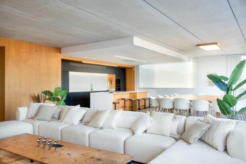 a living room with white couches and a table at Luxury Villa Lumina with Arcade & Pool Table, PS5 in Can Picafort