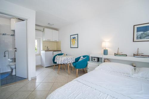 a bedroom with a bed and a table and chairs at Apartments Zoe in Bol