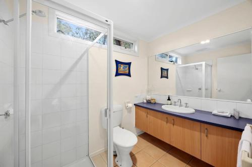 a bathroom with a shower and a toilet and a sink at Salty Haven in Moggs Creek