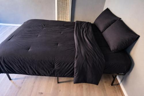 a black couch with two pillows on top of it at Hoover Vibe Near Public Transportation in Los Angeles