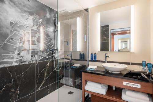 a bathroom with a sink and a shower at Radisson Blu Hotel, Montpellier in Montpellier