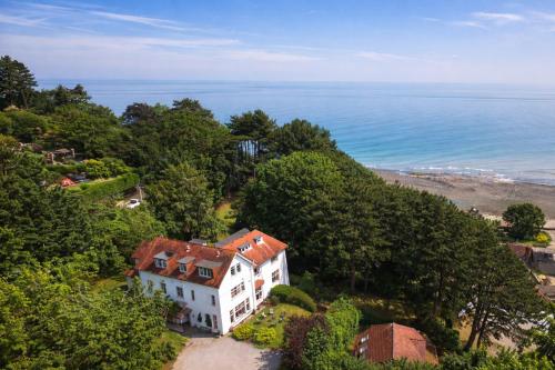 a house on a hill next to the ocean at Church Path Rooms in Minehead