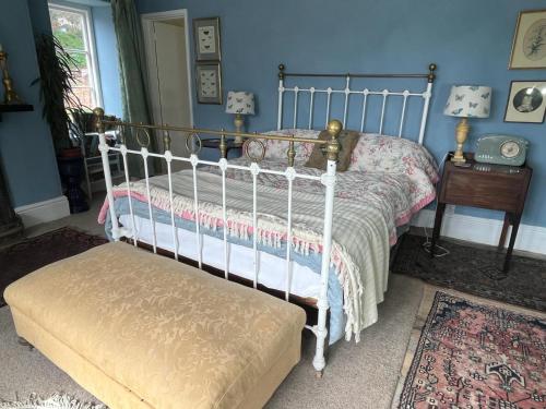 a bedroom with a bed and a bench in it at Church Path Rooms in Minehead