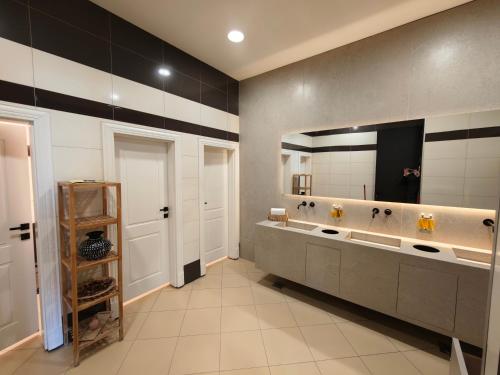 a bathroom with two sinks and a large mirror at Amazona Hotel in Prishtinë