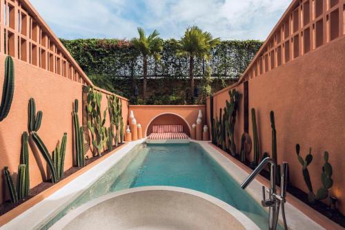 a swimming pool with a bath tub in a building at Cyrus Villa Seminyak by Ini Vie Hospitality in Seminyak