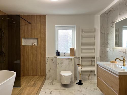 ein Badezimmer mit Badewanne, Toilette und Waschbecken in der Unterkunft Filuma Suite - Riverside Terrace on Gacka River in Otočac