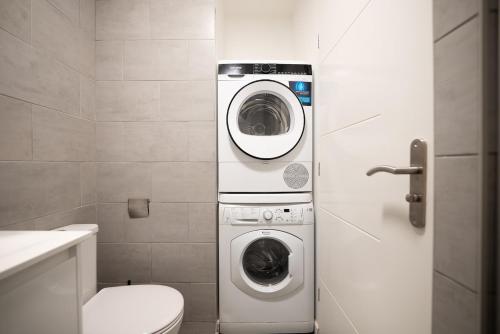 a bathroom with a washing machine and a toilet at Sky Two La Defense in Courbevoie