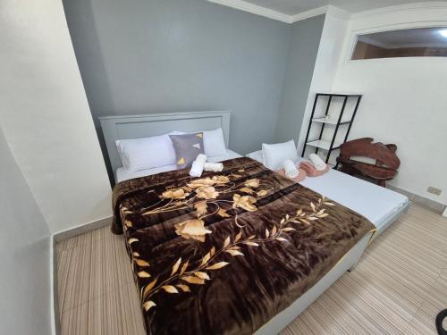a bedroom with a bed with a brown blanket at Door207 Homestay in Baguio
