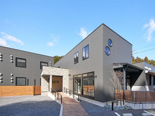 a large gray building with a parking lot at ホテルコンソラータ in Shingū