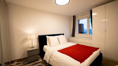 a bedroom with a bed with a red blanket and a window at Sky Two La Defense in Courbevoie