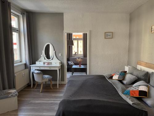 a bedroom with a bed and a desk and a mirror at Ferienapartment Weimar Altstadt 1 in Weimar