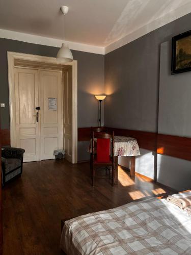a bedroom with a bed and a table and a door at Words & Swords in Krakow