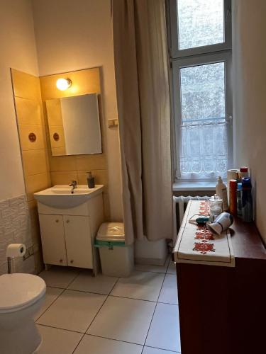 a bathroom with a sink and a toilet and a window at Words & Swords in Krakow