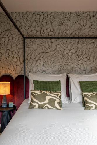 a bed with two pillows and a wall at Hotel Riche in Valkenburg
