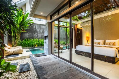 a bedroom in a villa with a bed and a pool at La Paradis Villa in Canggu