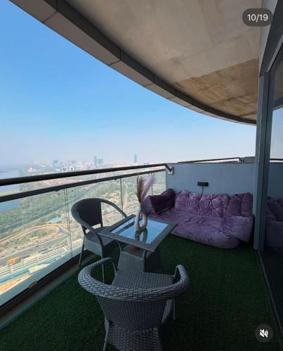 a balcony with a table and chairs and a couch at Noida Stay with Yamuna View in Noida