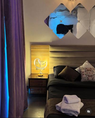 a room with a bed and a desk with a lamp at Noida Stay with Yamuna View in Noida