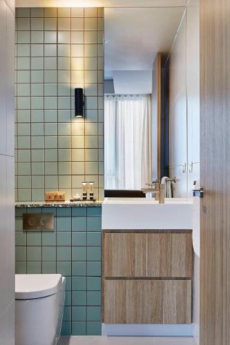 a bathroom with a toilet and a sink and a mirror at Urban Rest Lanbruk in Melbourne