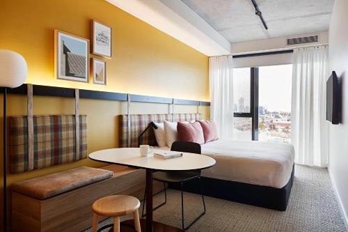 a hotel room with a bed and a table at Urban Rest Lanbruk in Melbourne