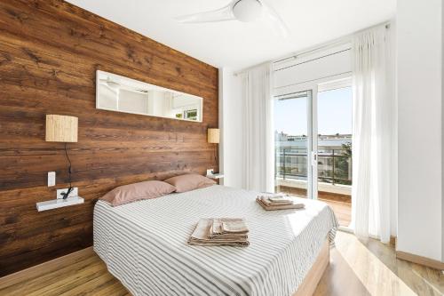 a bedroom with a bed with a wooden wall at MY ALVA PARK - 50m from the beach in Lloret de Mar