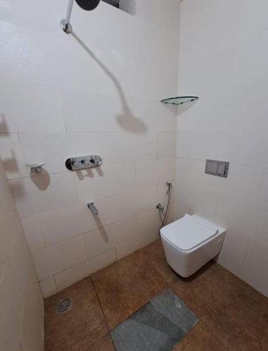 a bathroom with a toilet and a light on the wall at HALASE HOMESTAY mudigere in Mudigere