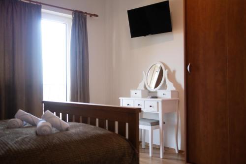 a bedroom with a bed and a desk with a mirror at Private Vineyard Villa with Heated Pool, Spa & BBQ by Destination GREEN Croatia in Velika