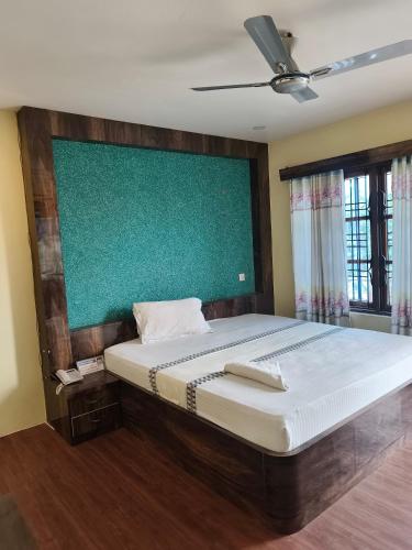a bedroom with a bed and a green wall at Domukha pali ghar in Chepti