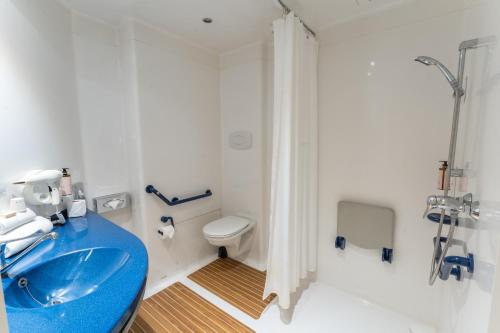 a bathroom with a blue sink and a toilet at Hotel Mercure Rennes Cesson in Cesson-Sévigné