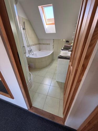 a bathroom with a bath tub and a sink at Pioppo Apartman in Tiszavasvári