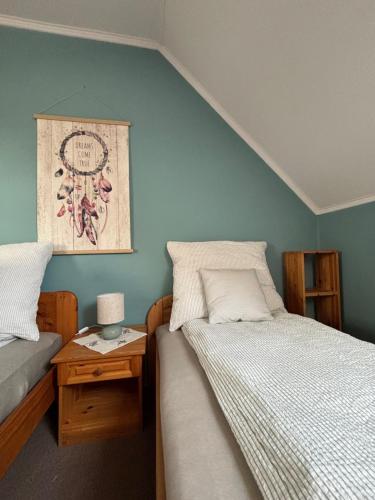 a bedroom with two beds and a table with a lamp at Pioppo Apartman in Tiszavasvári