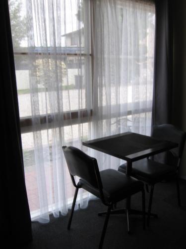 a table and two chairs in front of a window at Darlot Motor Inn in Horsham