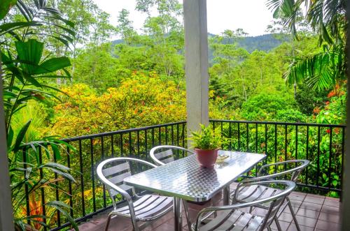 a table and chairs on a balcony with a view at Hanthana Villa in Kandy