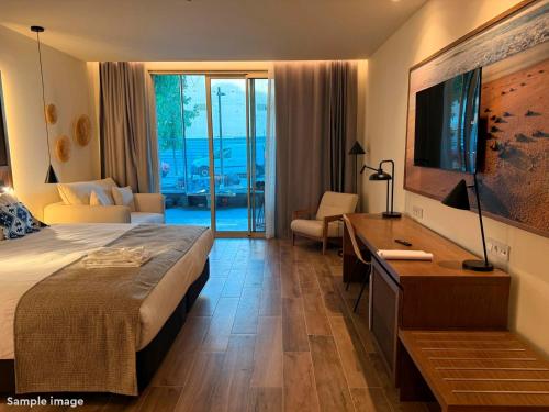 a hotel room with a bed and a desk with a television at ROBINSON BOA VISTA - All inclusive in Sal Rei