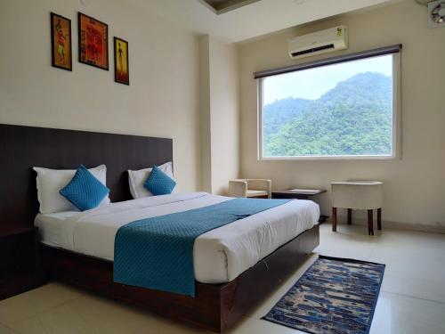 a bedroom with a large bed with a large window at Foxoso Heights, Tapovan in Rishīkesh