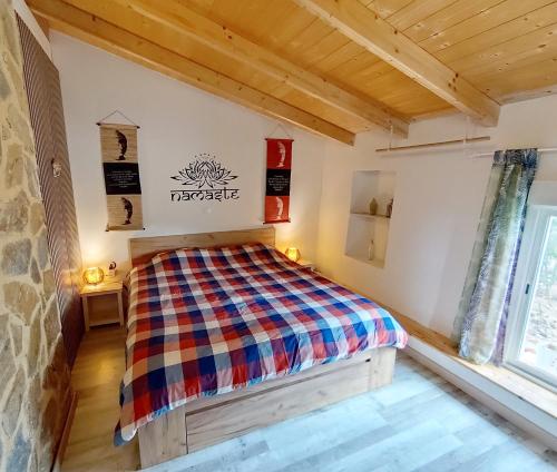 a bedroom with a bed with a checkered blanket at Casa Pura Vida in Relleu