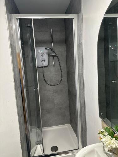 a shower in a bathroom with a glass door at Hostel & home Marlborough street in Dublin