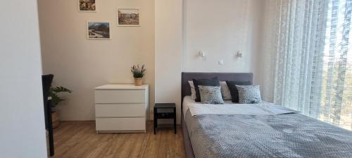 a bedroom with a bed and a dresser and a window at Apartament 39 in Lublin