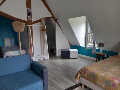 a bedroom with a bed and a couch in a room at La Cle de Saule in Saint-Maclou-de-Folleville