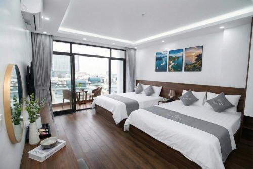 ein Hotelzimmer mit zwei Betten und einem Tisch in der Unterkunft Realux Hotel FLC Sam Son in Sầm Sơn