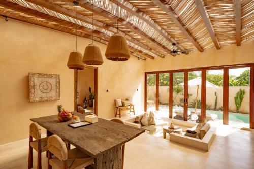 a living room with a wooden table and chairs at Villa Mahuwa in Canggu