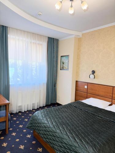 a hotel room with a bed and a window at Hotel Dobrodiy in Vinnytsya