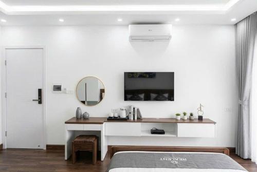 ein weißes Schlafzimmer mit Schreibtisch und Spiegel in der Unterkunft Realux Hotel FLC Sam Son in Sầm Sơn