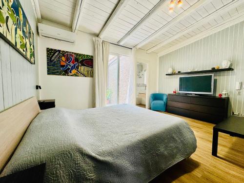 a bedroom with a large bed and a television at Luxury Allegra’s home in Syracuse