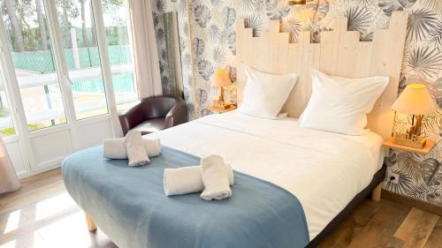 a bedroom with a bed with two towels on it at Hotel Les Rocailles in Montagnac